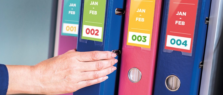 4 folders with different colour labels and a hand picking one off the shelf