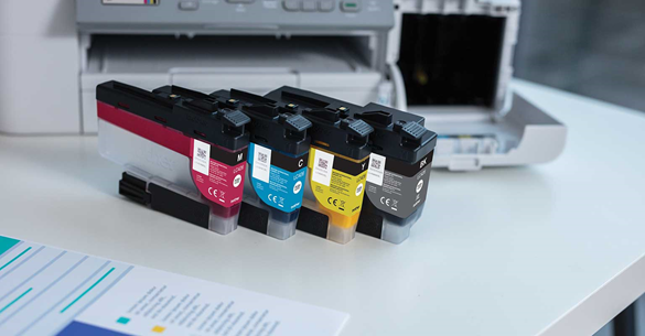 zoomed in image of brother colour printer, with colour cartridges next to it