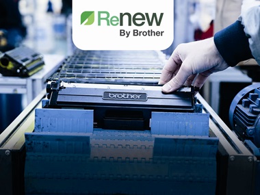 Production line of black Brother toner cartridges with a hand holding the one at the front with the Renew logo above in green